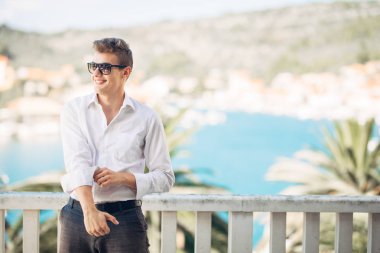 Denizin panoramik manzaralı lüks resort Hotel'de konaklamanın tadını yakışıklı delikanlı. Neşeli iş adamı kazanılan bir tropikal tatil gülümsüyor. Yaz tatili seyahat. Cruise