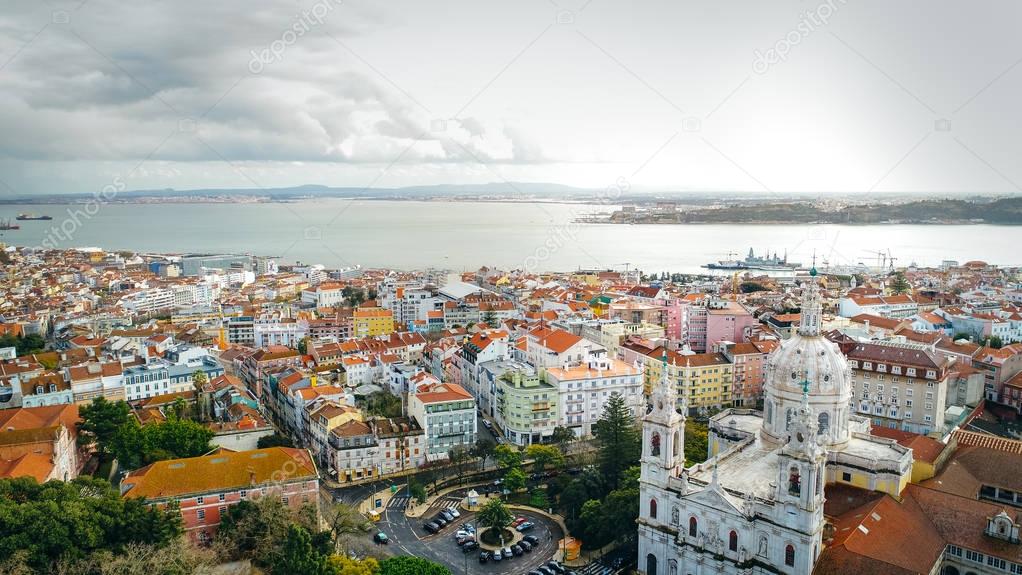 Aerial panoramic view over Lisbon in beautiful sunset sunshine.Saint George castle,downtown and neighbourhood of Alfama,river Tagus in european capital,Lisbon,Portugal.Aerial travel photography