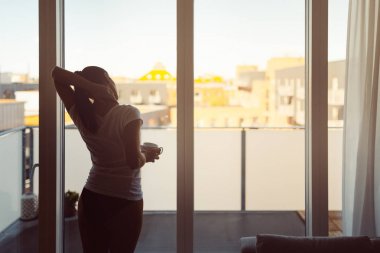 Pazartesi sabah güneşin erken uyanmak için germe, bir kahve içme uykulu kadın. Güne başlangıç. Wellbeing.Positive enerji, verimlilik, mutluluk, keyfi kavramı. Sabah ayini