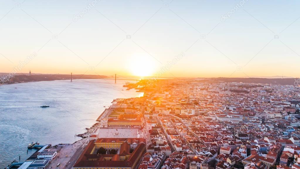 Aerial panoramic view over Lisbon in sunset sunshine.Tourists visiting Saint George castle beautiful view,downtown and neighbourhood of Alfama,Lisbon,Portugal.Aerial travel photography