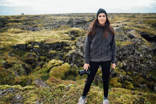 Woman traveler camping and exploring Iceland.Camping equipment and clothing for hikers and extreme weather conditions.Visiting Iceland and its natural beauty.Green moss meadows.Female hiker traveling.