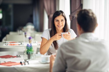 Bir tarihte bir restoranda otel bir yemeğin üzerine muhabbet gülümseyen kadın. Neşeli kadın müşteri bir ortağı ile kahve içme. Olumlu duygular, aşk, sevgi. Halka açık bir yerde davranır görgü