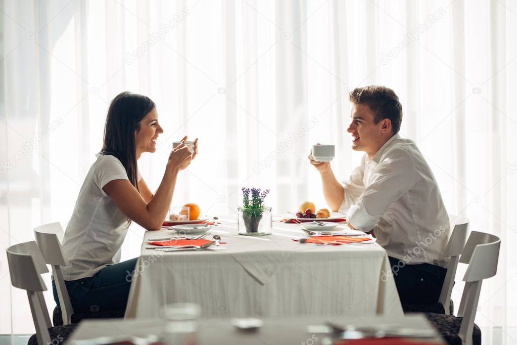 Happy couple at restaurant eating lunch.Talking over meal.Hotel full board,all inclusive stay.Travel, date,food,lifestyle.Smiling people having healthy breakfast.Food review.Manners at the table