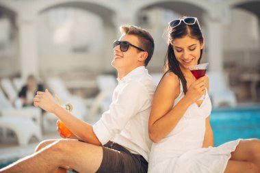 Havuz yaz tatil tatil kokteyller sahip iki çekici insan. Havuz lounge bar partisi. Zevk serinletici içecekler ve günün dinlenmek egzotik seyahat etmek tatil üzerinde bir çift gördüm. Arkadaşlar eğlenmeye