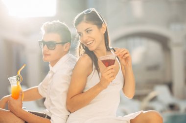 Havuz yaz tatil tatil kokteyller sahip iki çekici insan. Havuz lounge bar partisi. Zevk serinletici içecekler ve günün dinlenmek egzotik seyahat etmek tatil üzerinde bir çift gördüm. Balayı tatil