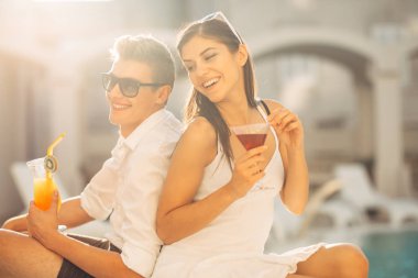 Havuz yaz tatil tatil kokteyller sahip iki çekici insan. Havuz lounge bar partisi. Zevk serinletici içecekler ve günün dinlenmek egzotik seyahat etmek tatil üzerinde bir çift gördüm. Balayı tatil