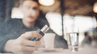 Using electronic cigarette to smoke in public places.Smoke restriction,smoking ban.Using vaping device with flavoured liquid.E-juice vaping new technology.Give up tobacco.Smoking habit,nicotine addict clipart