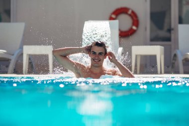 Havuzu spa gün zevk rahatlatıcı tatil beldesinde bir genç adam. Şımarık adam, metro cinsel, vücut ve refah bakmakta. Hidro masaj boyun ağrısı için. Altında su jet, boyun ve omurga masajı rahatlatıcı.