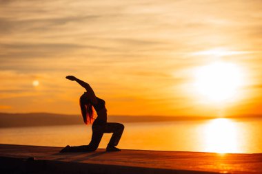 Düşüncesiz bir kadın doğası gereği meditasyon yapıyor. İç huzuru buluyor. Yoga yapıyor. İyileştirici bir yaşam tarzı. Huzurun, stres terapisinin, farkındalık meditasyonunun tadını çıkarıyor.