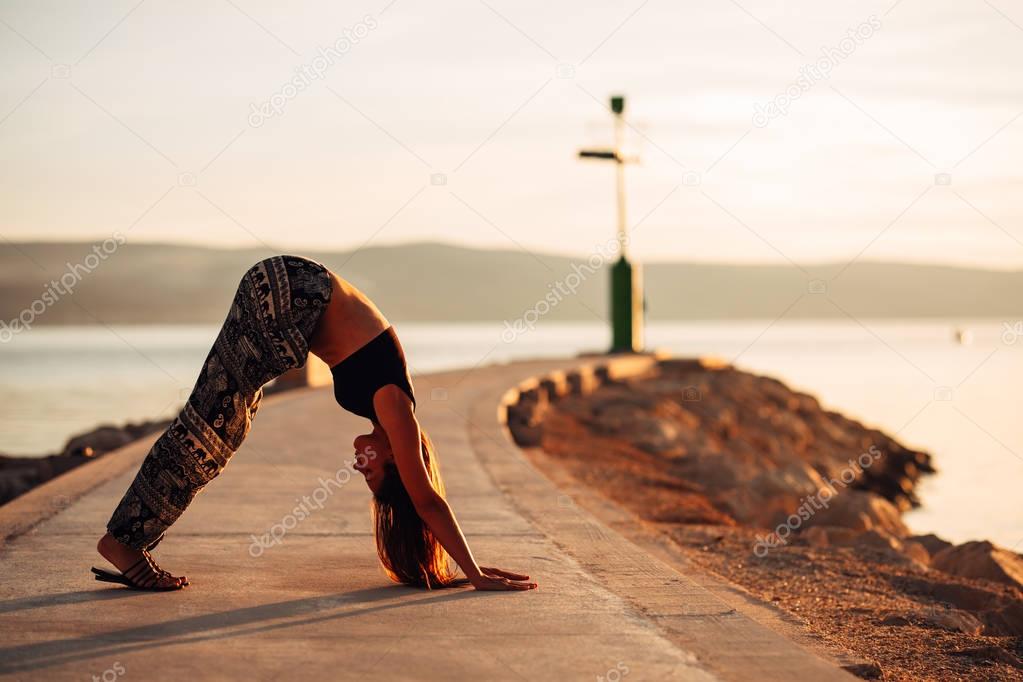 Carefree calm woman meditating in nature.Finding inner peace.Yoga practice.Spiritual healing lifestyle.Enjoying peace,anti-stress therapy,mindfulness meditation.Positive energy.Downward facing dog