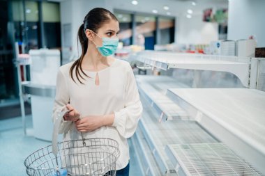 Salgın sırasında alışveriş. Koruyucu bir maske takan alıcı. Coronavirus salgını sırasında panik satın alma. Acil durum sırasında eczanelerde ve eczanelerde eksiklik..