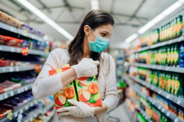 Vitamin ve minerallerin doğal kaynağı. Meyve suyu antioksidanları. Süpermarketten yüz maskesi takan kadın. Virüs salgınına hazırlık yapan kadın.