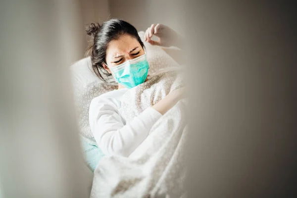 Gezici karantina hastane ünitelerinde maskeli hasta kadın. Coronavirus Covid-19 hastası zatürree belirtileri gösteriyor. Sağlık tedavisinde. Acı verici öksürük.