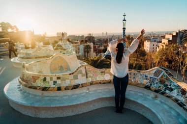 Neşeli kadın turist Parc Guell 'i ziyaret ediyor, Barcelona, İspanya' da ünlü bir halk parkı. Grcia bölgesinde La Salut mahallesini geziyor. İspanya 'da tatil. Avrupa 'ya seyahat, UNESCO' nun ünlü tarihi yapılarını ziyaret etmek.