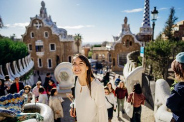 Neşeli kadın turist Parc Guell 'i ziyaret ediyor, Barcelona, İspanya' da ünlü bir halk parkı. Grcia bölgesinde La Salut mahallesini geziyor. İspanya 'da tatil. Avrupa 'ya seyahat, UNESCO' nun ünlü tarihi yapılarını ziyaret etmek.