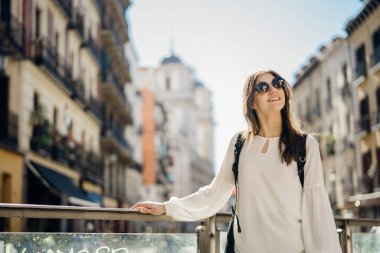 Madrid, İspanya 'yı ziyaret eden gülümseyen genç bir kadın. Tarihi bir yeri ziyaret ediyor. Bütçeyle seyahat ediyor.