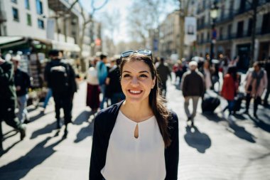 Barselona, İspanya 'da, La Rambla caddesinde gezen neşeli genç bir bayan turist. Barselona' nın ünlü alışveriş caddesinde yürüyor. Seyahatin tadını çıkarıyor. Bir Treveler kadınının gözlerinde neşe.