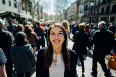 Barselona, İspanya 'da, La Rambla caddesinde gezen neşeli genç bir bayan turist. Barselona' nın ünlü alışveriş caddesinde yürüyor. Seyahatin tadını çıkarıyor. Bir Treveler kadınının gözlerinde neşe.