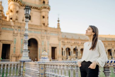 Güzel tarihi manzaranın tadını çıkarıyor. Sevilla, Endülüs, İspanya 'da Plaza de Espana' ya bakan genç turist kadın. İspanya 'da gün batımı. Avrupa meydanında dalgın bir kadın..