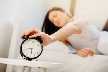 Alarm çalıyor. Sabahın erken saatlerinde kadın iş için uyanıyor. Sızıntı bozukluğu. Aşırı uyuyan yorgun kadın, uykusuz kalmışlık.