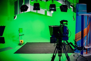 TV Studio recording show.Reportage shooting.TV NEWS program studio with video camera lens and lights.Positioned stage big professional broadcasting camera with headphones.Green key studio clipart
