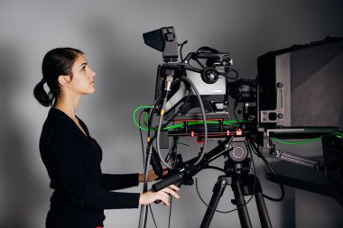 TV stüdyosunda kayıt programı. Televizyon haber yayınında kameralı profesyonel kamera operatörü. Kameraman kadın büyük konumlu bir yayın kamerasıyla çalışıyor.