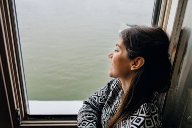 Genç bir kadın boş zamanlarını evde geçirir. Bakar, evde kalır, manzaranın tadını çıkarır, pencereye bakar. Evde karantina altındadır..