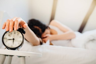 Alarm çalıyor. Kadın sabah iş için erken kalkıyor. Uyku apnesi engelleyici etkenler. Zihinsel stres uykusuzluğu. Melatonin eksikliği.
