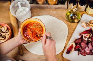 Ev hanımı çabucak ev yapımı domatesli pizza sosu yapıyor. Geleneksel pizza tabanlı salsa tarifi. Gurme ketçap. Evde yemek ve yemek pişirme.