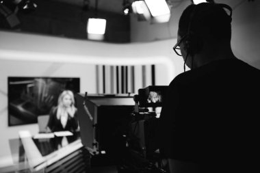 TV haber stüdyosunda, dünya çapında haber yapan televizyon sunucusu gazeteci kamera ekipmanlarıyla kayıt. Canlı yayın sırasında televizyon spikeri. TV direktörü / editörü. Mass media