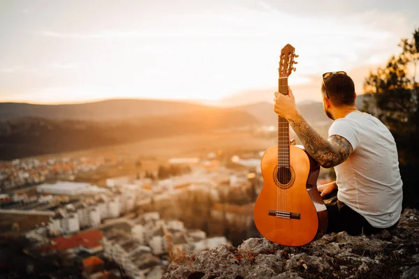 Ung Man Som Håller Akustisk Gitarr Och Letar Efter Solnedgången — Stockfoto