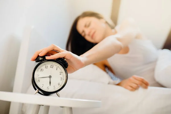 目覚まし時計リング 仕事のための早朝に目を覚ます女性 睡眠障害 寝坊疲れ女性 悪い睡眠品質 睡眠は瞬間を奪われました 慣性を起こします 悪夢を夢見て後に悪い気分 不眠症 — ストック写真