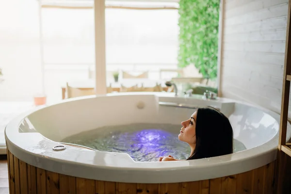 Woman having a spa day  moment in modern bathroom indoors.Relaxing at home in the hot tub bath.Indoors jacuzzi tub.Leisure activity.Self care.Body nourishment.Skincare,spa and aromatherapy.Antistress
