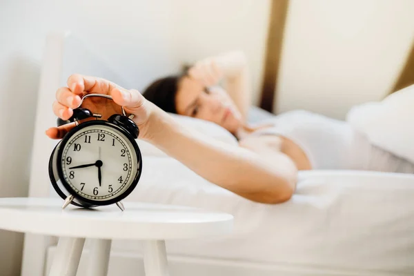 目覚まし時計リング 仕事のための早朝に目を覚ます女性 睡眠障害 寝坊疲れ女性 悪い睡眠品質 睡眠は瞬間を奪われました 慣性を起こします 悪夢を夢見て後に悪い気分 不眠症 — ストック写真