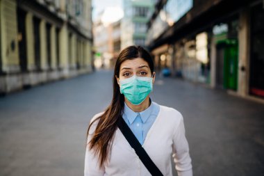 COVID-19 'dan etkilenen endişeli genç yetişkin. Yürümek, pandemic sırasında işe gitmek. Koruyucu tedbirler, maske takmak ve sosyal mesafeler. Kılavuza uymak. Temastan kaçınmak.