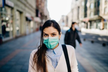 Şüpheli bir genç yetişkin pandemic sırasında kamusal alanda yürüyor. COVID-19 'un etkisi. Koruyucu tedbir, maske takmak. Kılavuzlara saygı. Boş sokaklar.