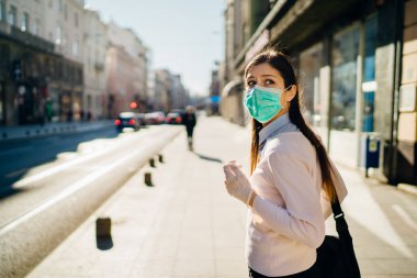 COVID-19 'dan etkilenen endişeli genç yetişkin. Yürümek, pandemic sırasında işe gitmek. Koruyucu tedbirler, maske takmak ve sosyal mesafeler. Kılavuza uymak. Temastan kaçınmak.