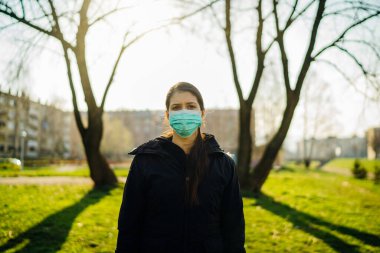 Bahar doğasında hastalığa yakalanmamak için maske takan depresif bir insan. Coronavirüs salgını. Panik ve enfeksiyon korkusu. COVID-19.Karantina zihinsel stresinin duygusal etkisi.