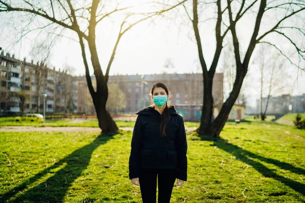Depressed scared person wearing a mask to prevent disease spread in spring nature.Coronavirus pandemic dull life.Infection panic and fear.Emotional effect of the COVID-19.Quarantine mental stress