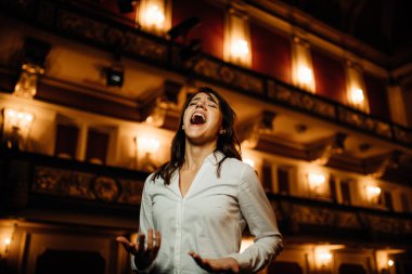 Gösterici, boş bir tiyatroda konser veriyor, hayranları olmadan konser veriyor. Seyirci yok. COVID-19 iptal edildi. İzleyicisiz opera binası. Eğlence sektörü krizleri.