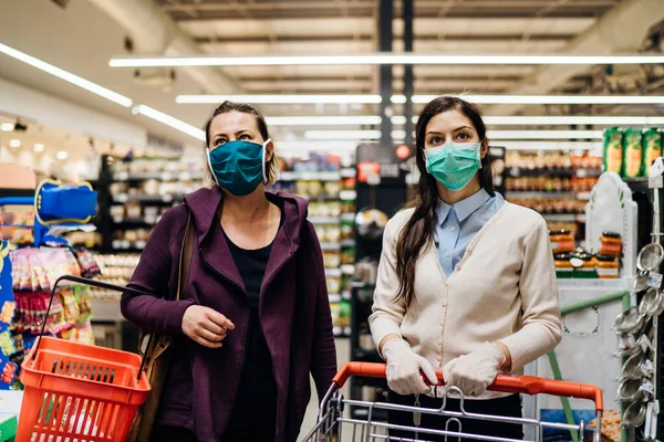 Manavda koronavirüs salgını nedeniyle market alışverişi yapan maskeli müşteriler. COVID-19 gıda alışverişi. Karantina hazırlığı. Panik satın alma ve stoklama.