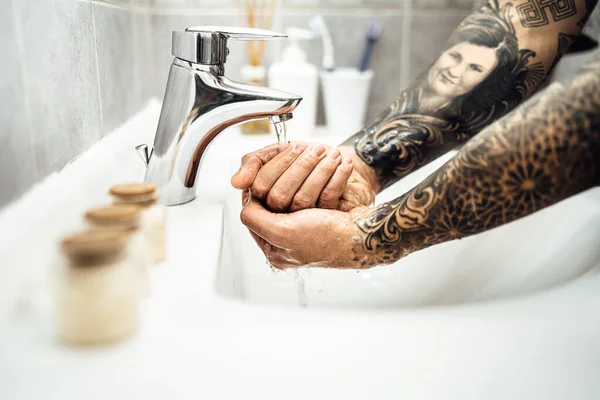 Man washing hands with soap and water in clean bathroom.Decontamination protocol,hand hygiene routine.Cleaning hands regularly.Infectious disease prevention/protection.Handwashing disinfection