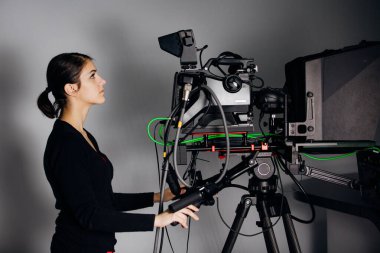 TV stüdyosunda kayıt programı. Televizyon haber yayınında kameralı profesyonel kamera operatörü. Kameraman kadın büyük konumlu bir yayın kamerasıyla çalışıyor.