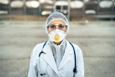 Karantina hastanesi önünde aşırı çalışan üzgün sağlık görevlisi. Korku ve psikolojik stres içinde acil servis doktoru. Corona virüsüyle mücadele baskısı.
