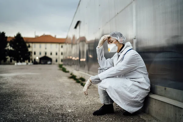 Depressed crying doctor with mask having mental breakdown.Fear,anxiety,panic attack due to coronavirus outbreak.Psychological effects of COVID-19.PTSD.Mental health,coping with death