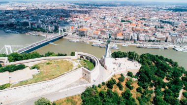 BUDAPEST / HUNGARY-circa Haziran 2018: Macaristan 'ın Budapeşte kentindeki Tuna Nehri üzerindeki Özgürlük Köprüsü ile Macar Özgürlük Heykeli' nin havadan görünüşü. Gellert Tepesi 'ndeki Kale. Özgürlük Anıtı