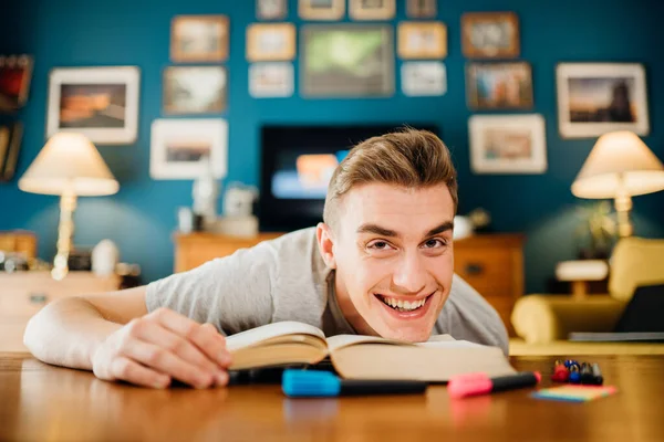 Smiling man studying from home.Bored student studying for exams.Student having online distance learning class.Quarantine home school education.Learning new things in free time.Highlighting markers