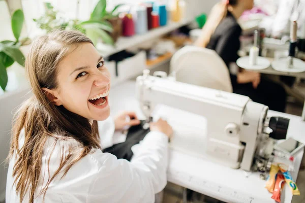 Dikiş makinesinde çalışan heyecanlı yaratıcı terzi. El yapımı koruyucu pamuk maskesi yapımı. DIY projesi, dikiş makinesi dikmeyi öğrenme. Kurs dikme hobisi. Giysi endüstrisinde mutlu terzi.