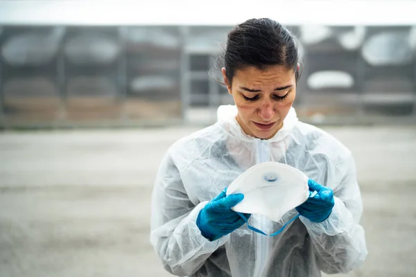 Yorgun ağlayan doktor / hemşire Coronavirus koruyucu giysisi N95 maskesi. Kapsamlı 19 salgın. Ölümcül salgın. Ön saflarda çalışan işçilerin zihinsel stresi, yanma.
