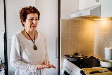 Evde ağlayan yaşlı bir kadın var, kötü haberler duyuyor. Coronavirus COVID-19 salgını salgını. Enfekte olmuş akraba / arkadaş. Toplumsallaşma kısıtlaması.